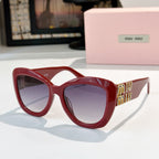 MiuMiu cat-eye sunglasses with red frames and purple tinted lenses, gold logo arms