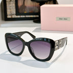 MiuMiu cat-eye sunglasses with dark teal frames and purple tinted lenses, logo arms