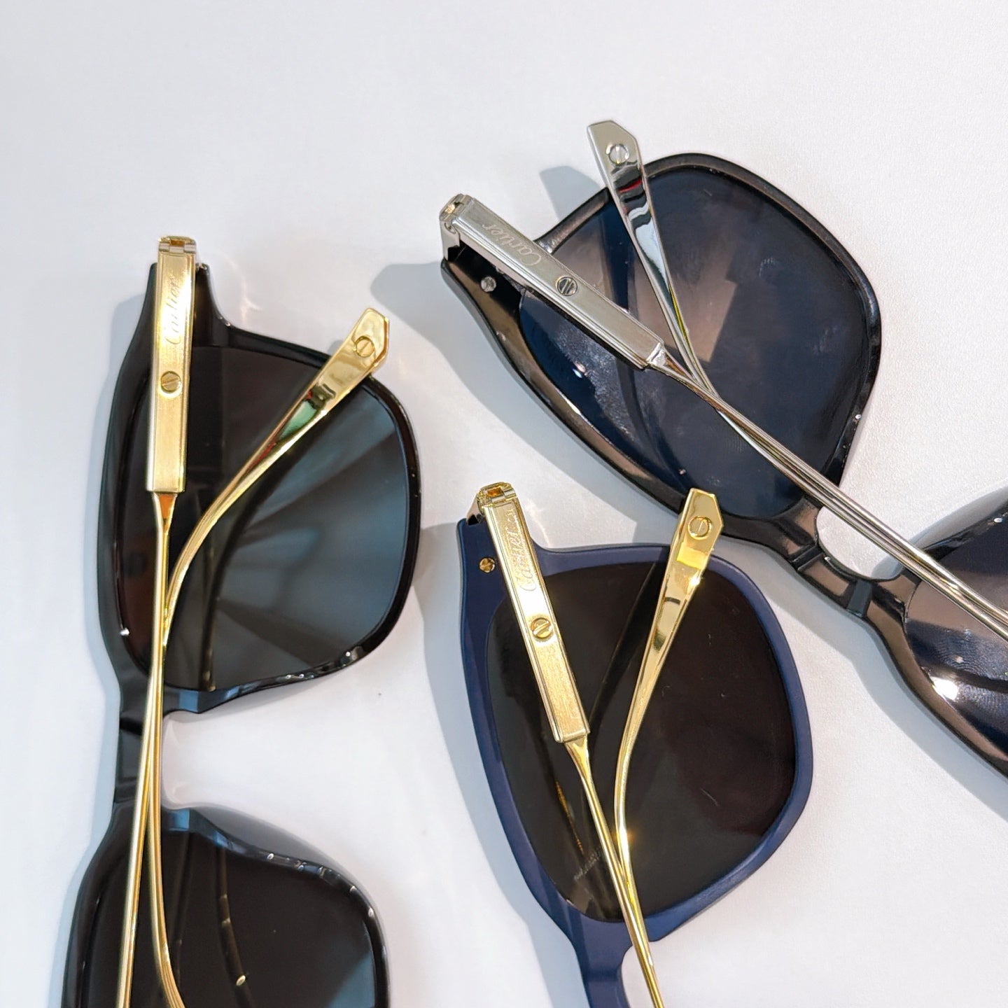 Set of sunglasses with dark lenses and gold-tone metal frames, various colorways.