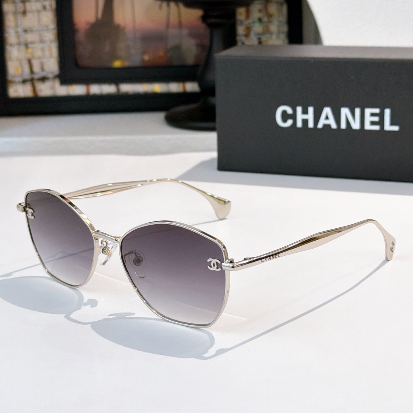 Gold-rim cat-eye sunglasses with dark gray lenses and thin metal arms