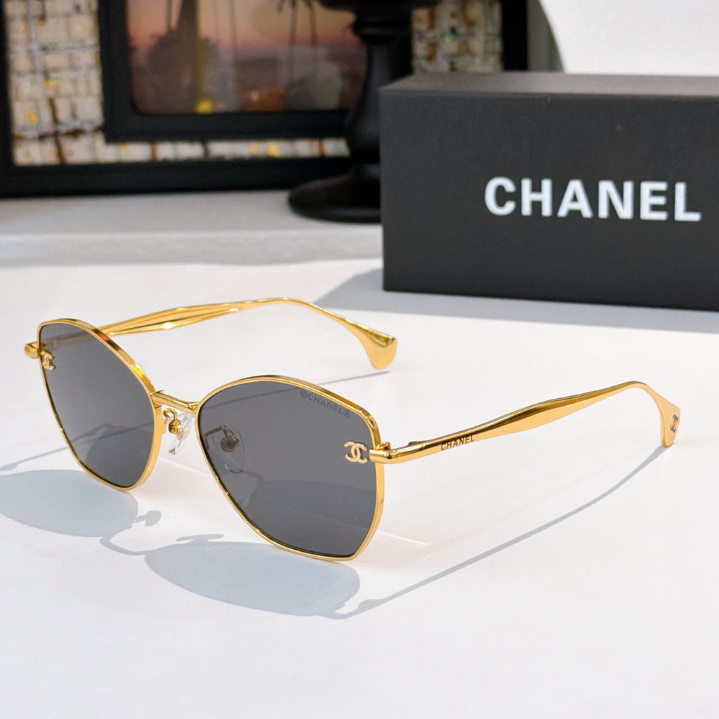 Gold-rim cat-eye sunglasses with dark gray lenses and thin metal arms