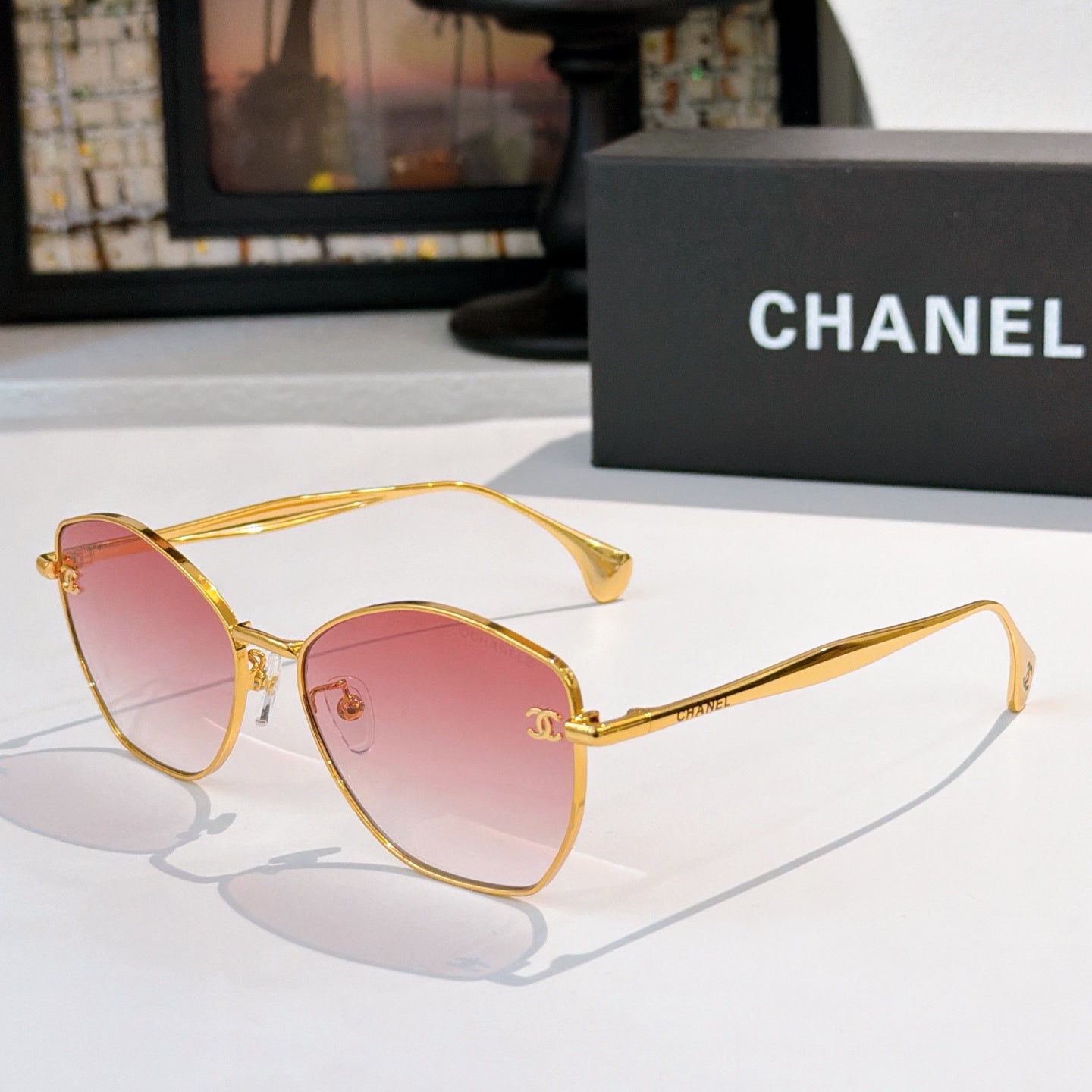Gold-rim cat-eye sunglasses with pink tinted lenses and slim metal arms