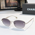 Sunglasses with gold-tone frame and dark purple-gray tinted lenses, oval shape