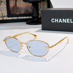 Sunglasses with gold-tone frame and light blue tinted lenses, oval shape