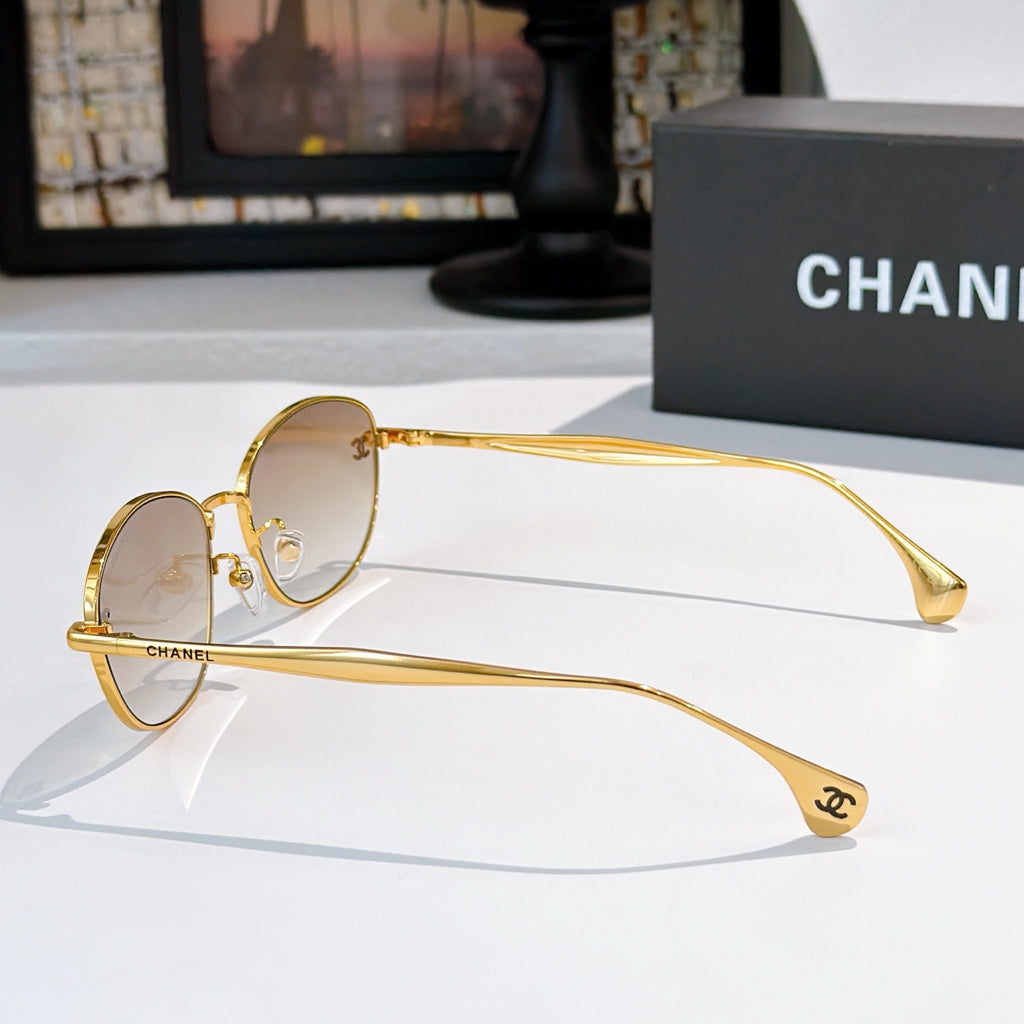 Sunglasses with gold-tone frame and light tinted lenses, side profile view