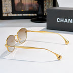 Sunglasses with gold-tone frame and light tinted lenses, side profile view