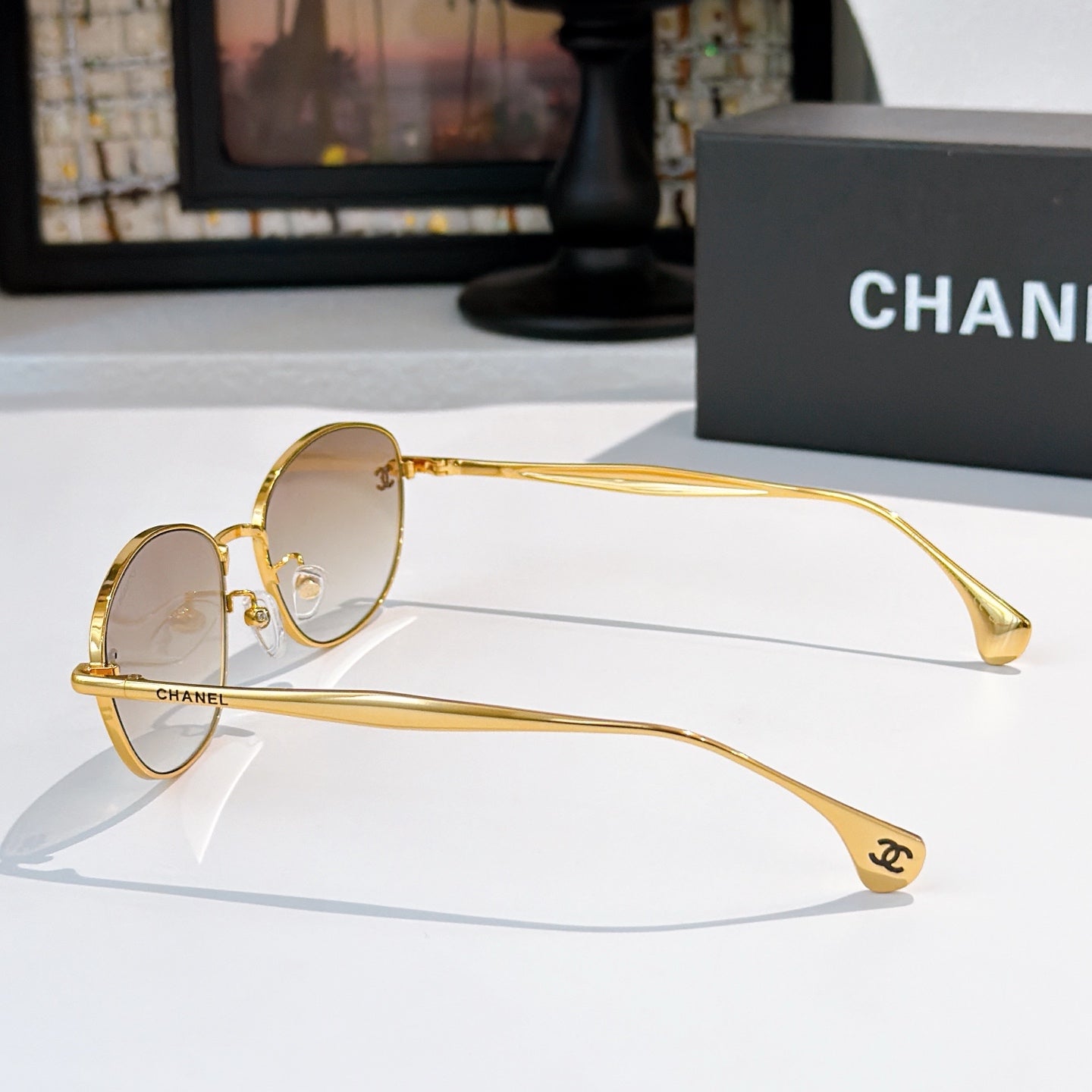 Sunglasses with gold-tone frame and light tinted lenses, side profile view