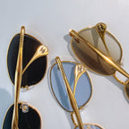 Gold-framed sunglasses close-up with dark and light tinted lenses