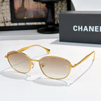Sunglasses with gold-tone frame and light gray tinted lenses, oval shape