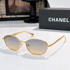 Sunglasses with gold-tone frame and light gray tinted lenses, oval shape
