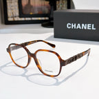 Chanel eyeglasses with tortoiseshell frames, clear lenses, and logo temple detail.