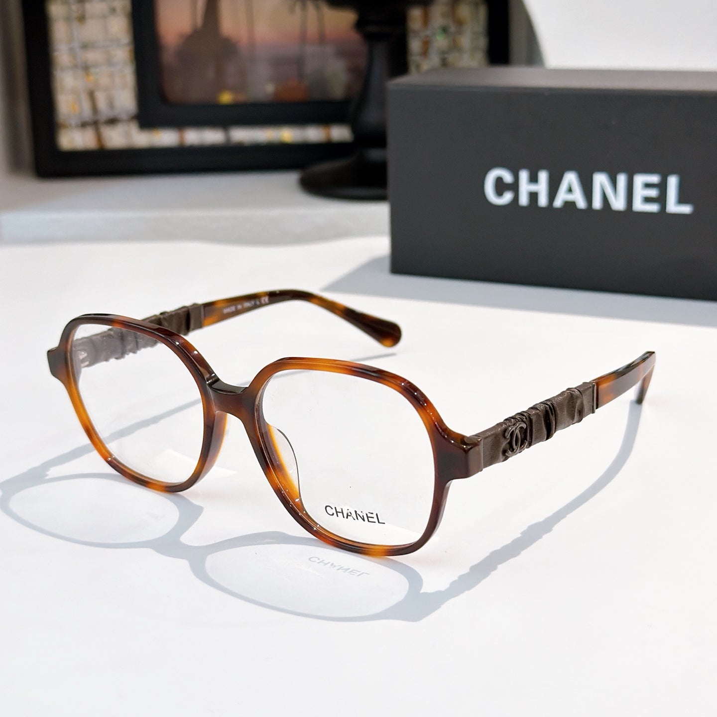 Chanel eyeglasses with tortoiseshell frames, clear lenses, and logo temple detail.