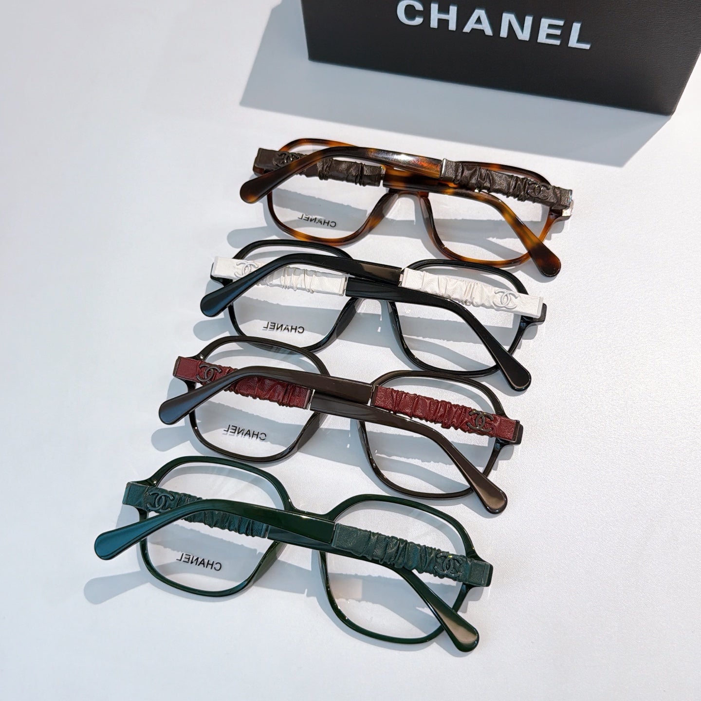 Chanel eyeglasses set with tortoiseshell, black, maroon, and green frames.