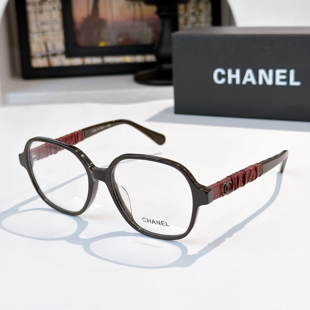 Chanel eyeglasses with dark frames, clear lenses, and burgundy ribbed temple detail.