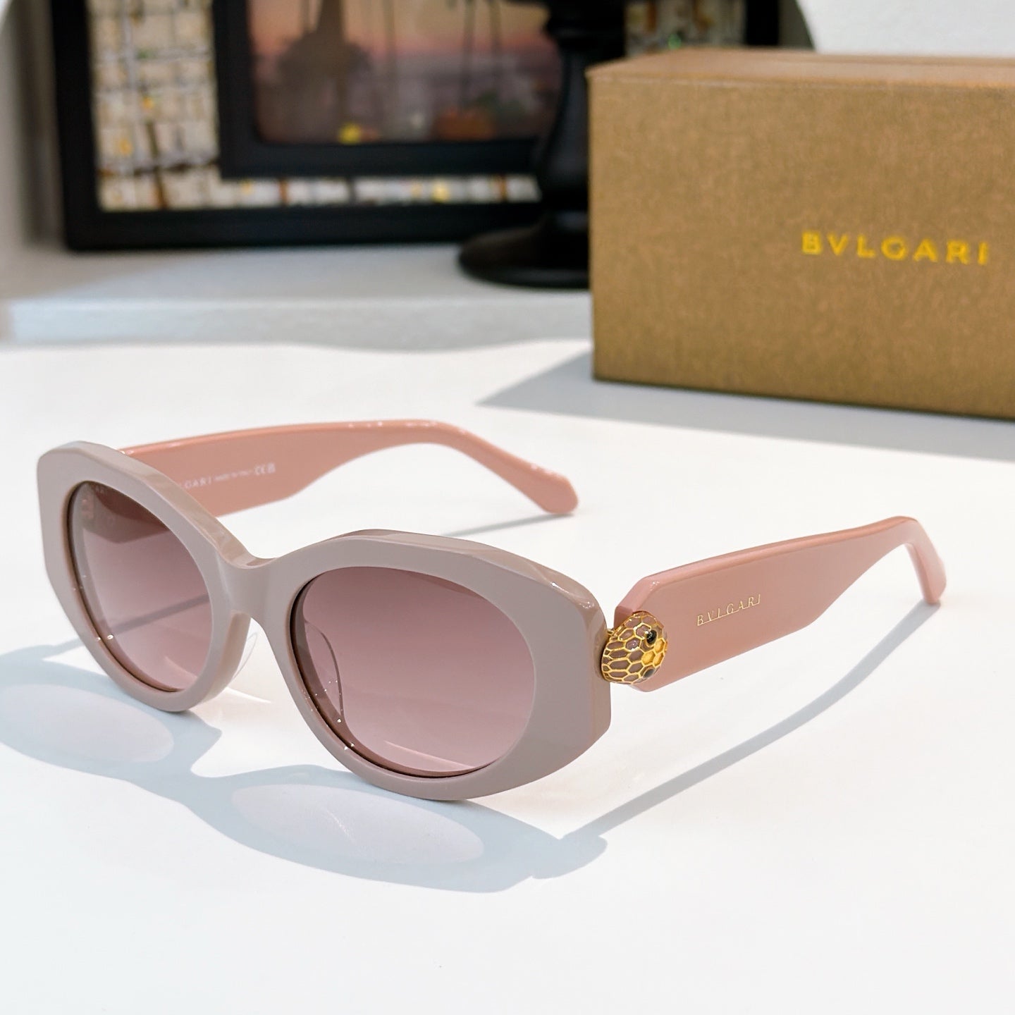 Light pink Bvlgari round-frame sunglasses with gold logo temple detail and rose lenses