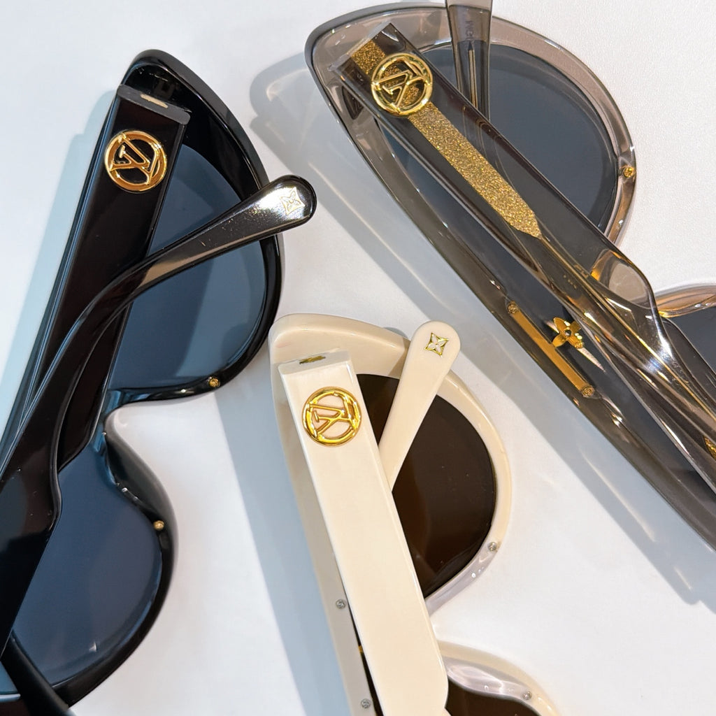 Louis Vuitton sunglasses close-up with gold logo hardware and tinted lenses