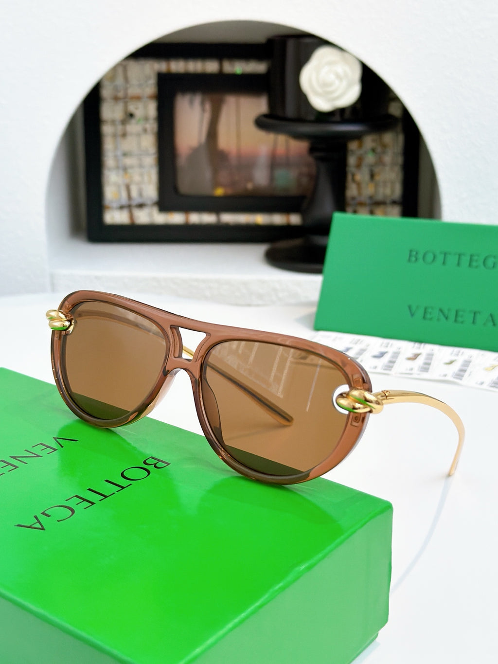 Sunglasses with light brown frame and gold-tone accents, brown-tinted lenses.
