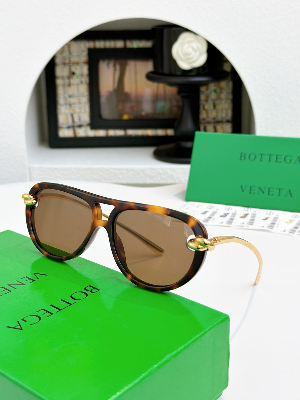 Sunglasses with tortoise-pattern frame and gold-tone accents, brown-tinted lenses.