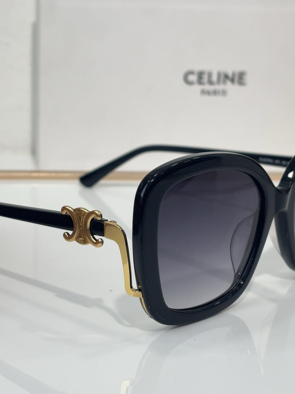 Celine black oval sunglasses with dark tinted lenses and gold-toned hinge accents