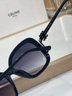 Celine black sunglasses with engraved temple logo and dark tinted lenses