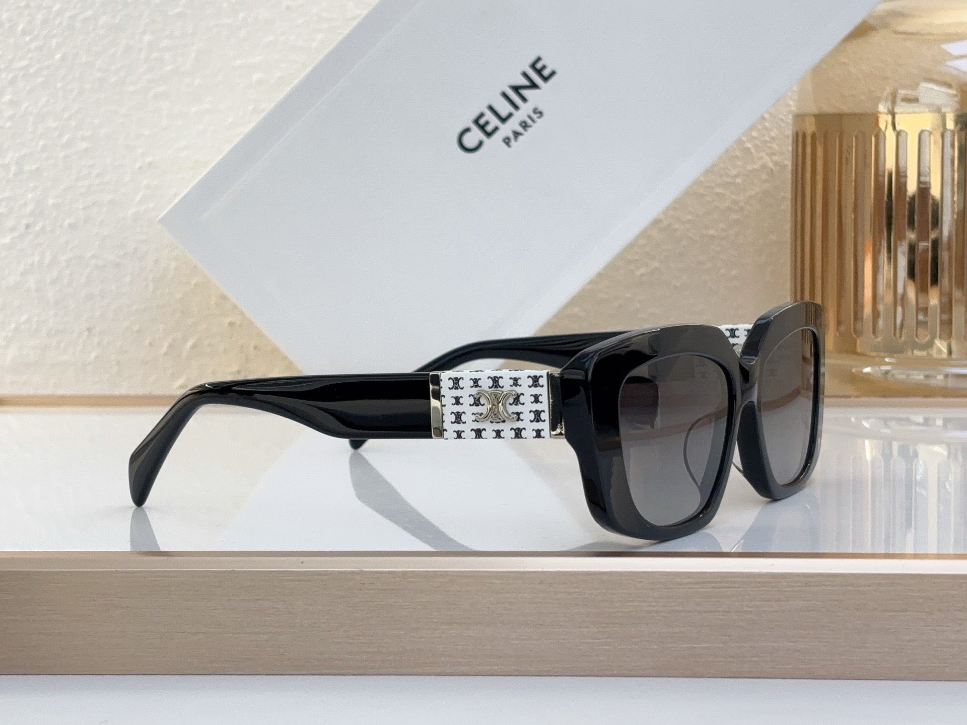 Celine sunglasses with black frame, patterned temple, and dark tinted lenses