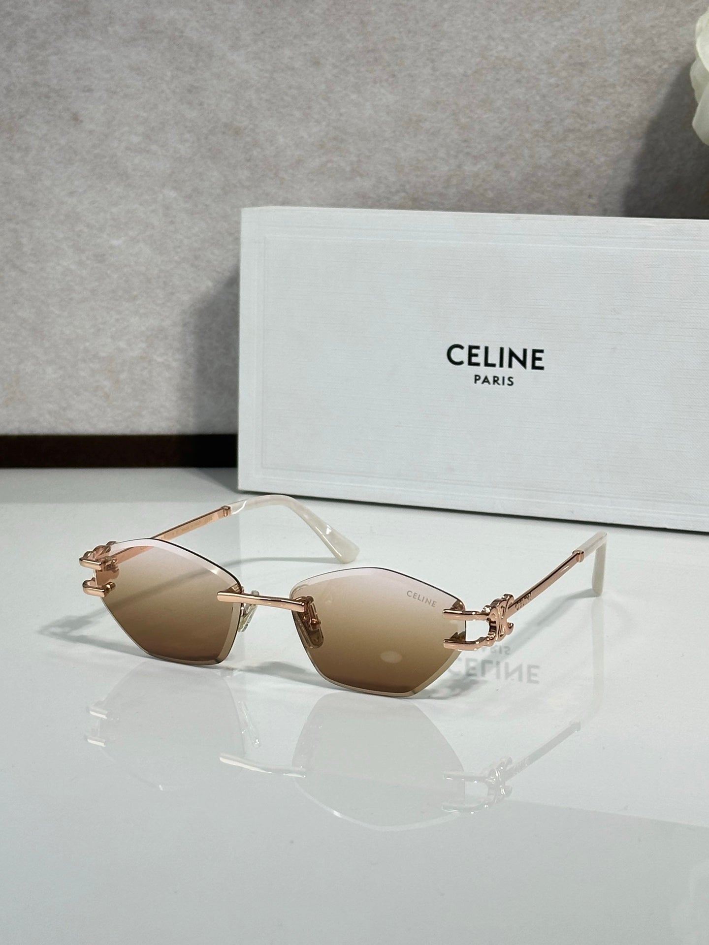 Metal-framed sunglasses with light tan lenses and gold-tone temple arms