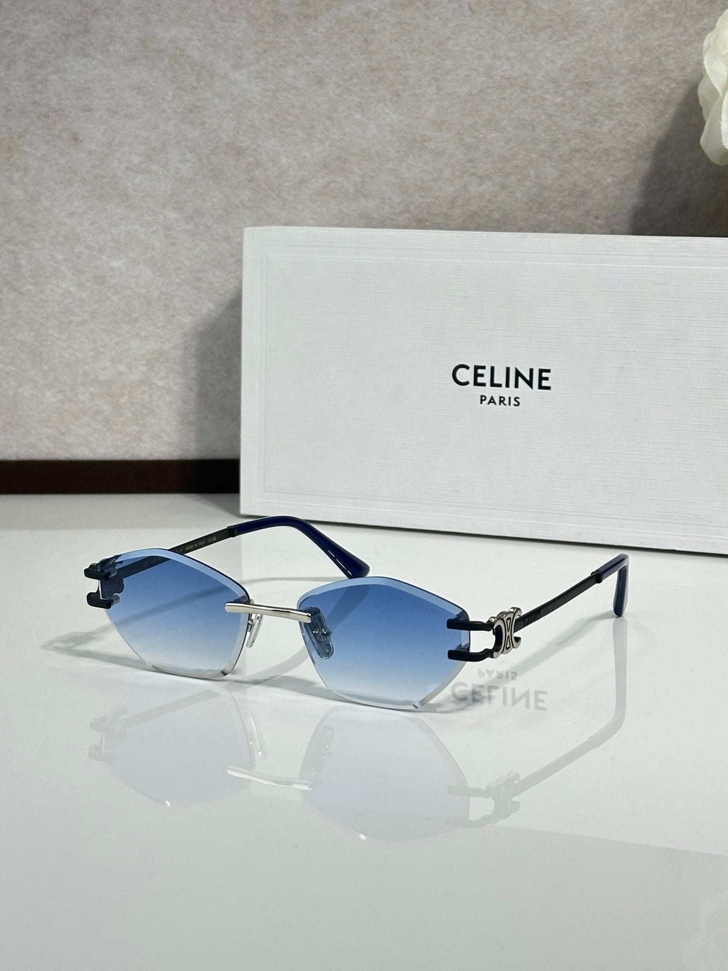 Metal-framed sunglasses with blue gradient lenses and gold-tone accents