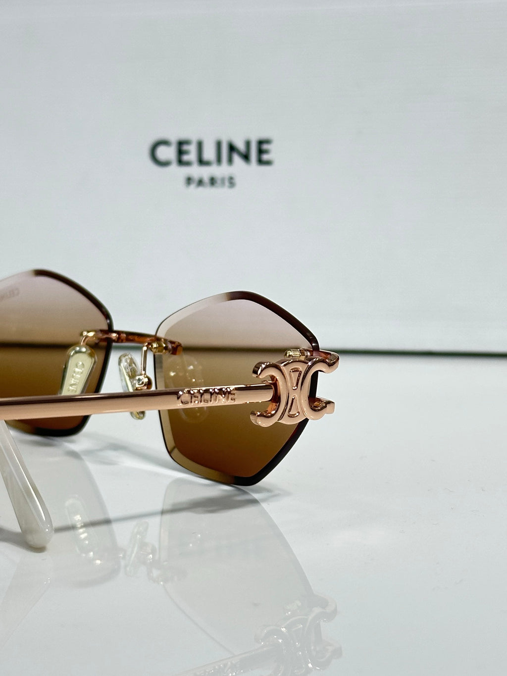 Metal-framed sunglasses with brown gradient lenses and gold-tone hinge detail