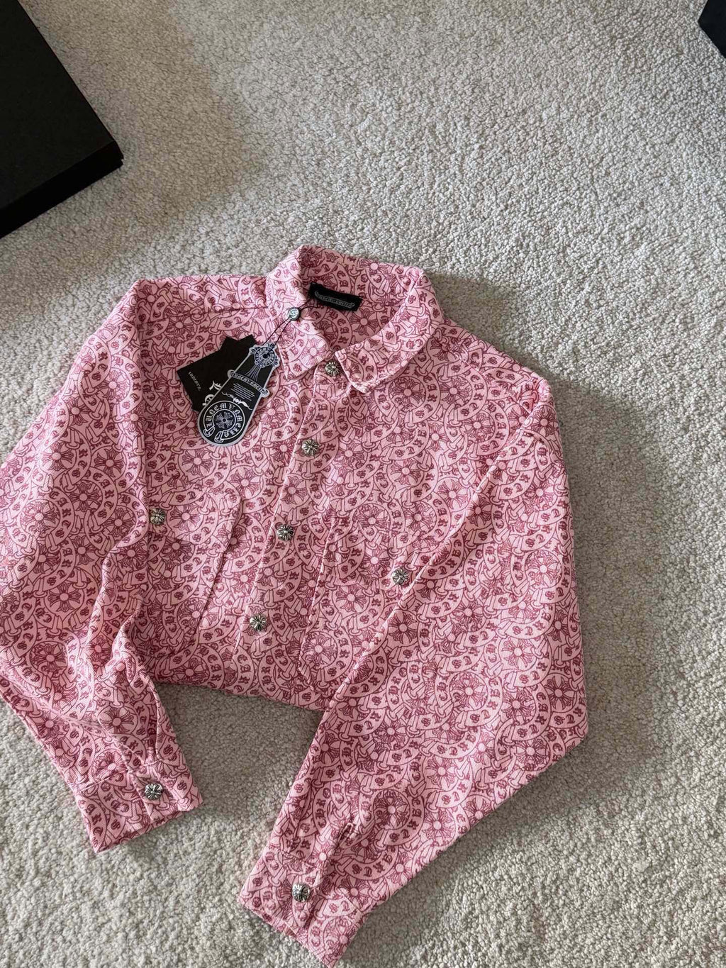 Pink long-sleeve button-up shirt with all-over pattern and front button closures