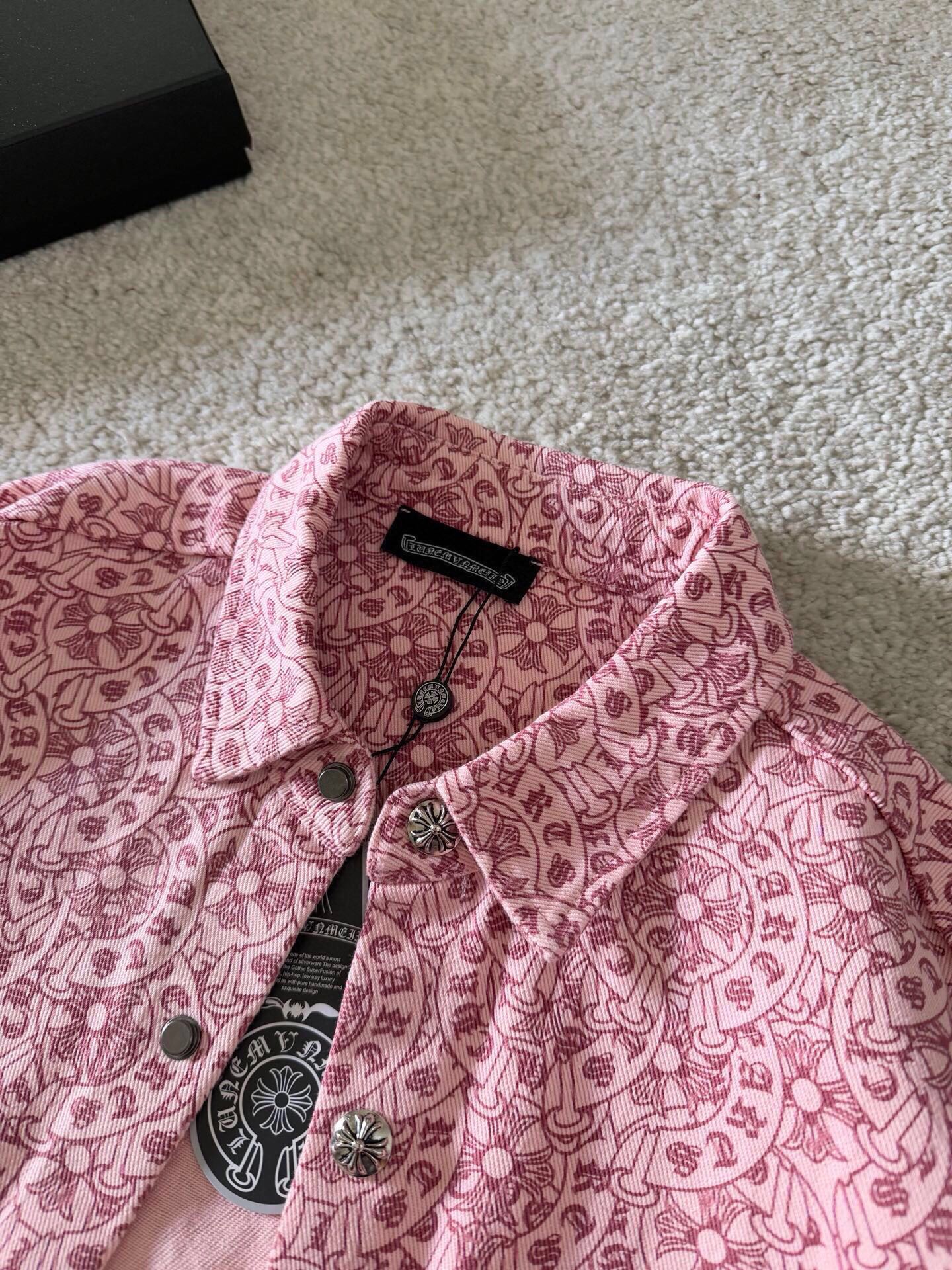 Pink patterned long-sleeve shirt with black brand tag at collar and buttons