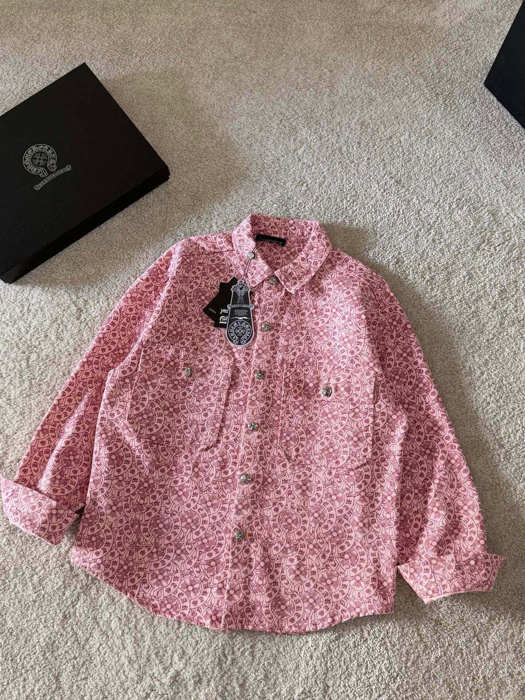 Pink long-sleeve button-up shirt with pointed collar and patterned button placket