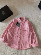 Pink long-sleeve button-up shirt with pointed collar and patterned button placket