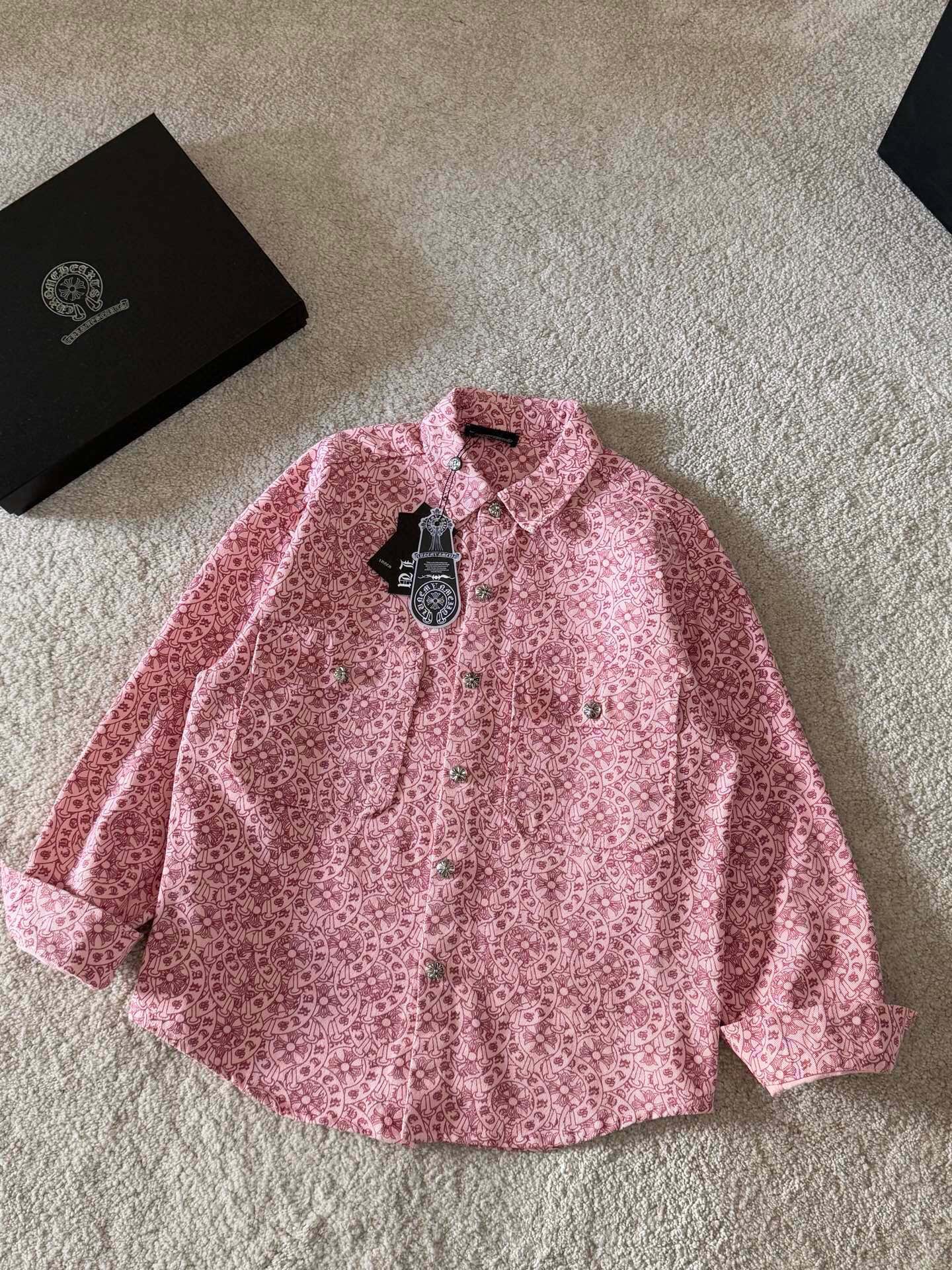 Pink long-sleeve button-up shirt with pointed collar and patterned button placket
