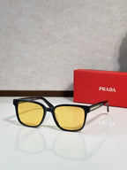 Prada sunglasses with black frame and yellow-tinted lenses