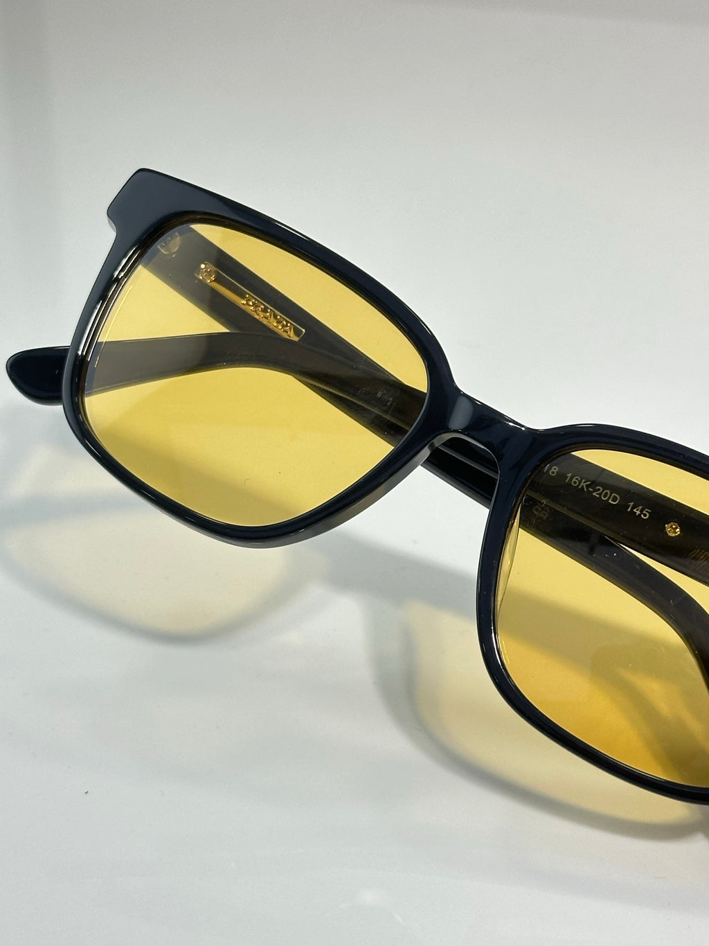 Prada sunglasses close-up with black frame and yellow-tinted lenses