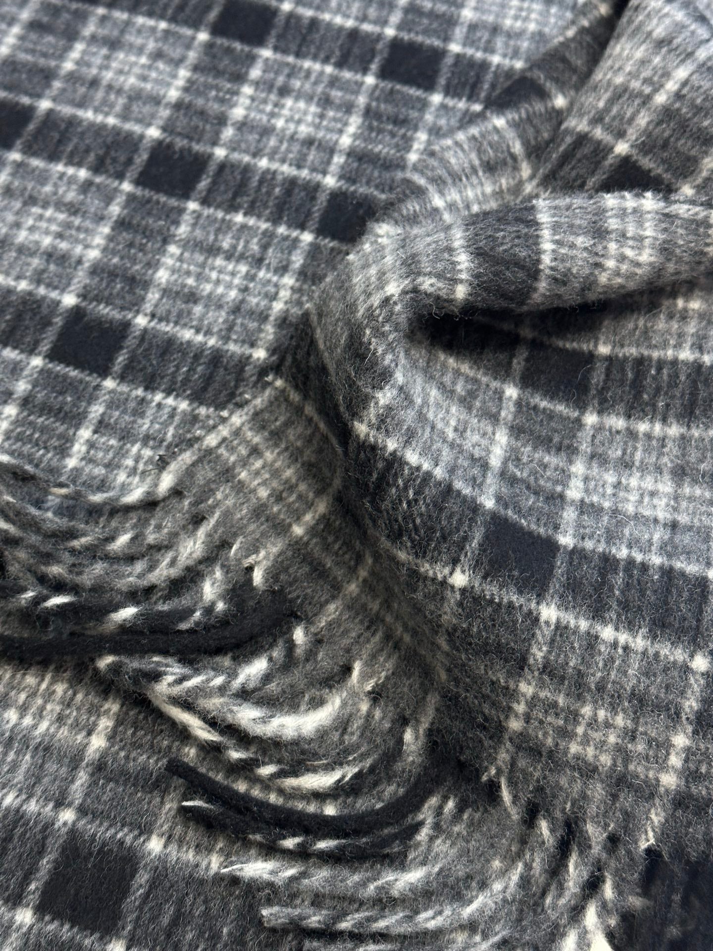Plaid poncho fabric with stitched fringe and textured weave