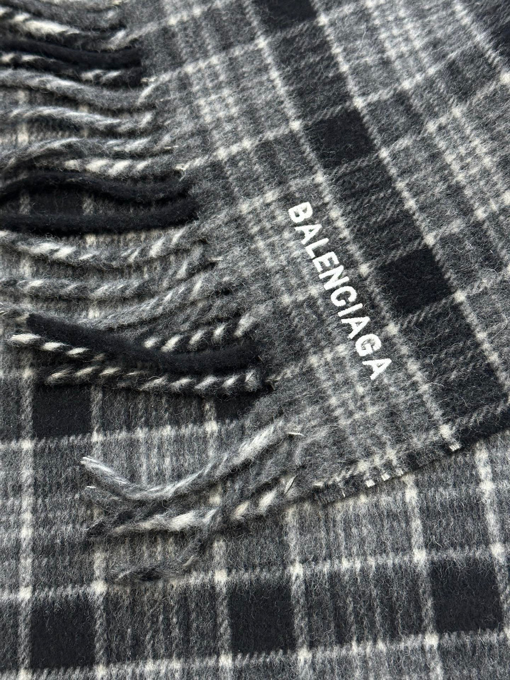 Balenciaga logo tag on plaid poncho with fringed edge