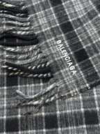 Balenciaga logo tag on plaid poncho with fringed edge