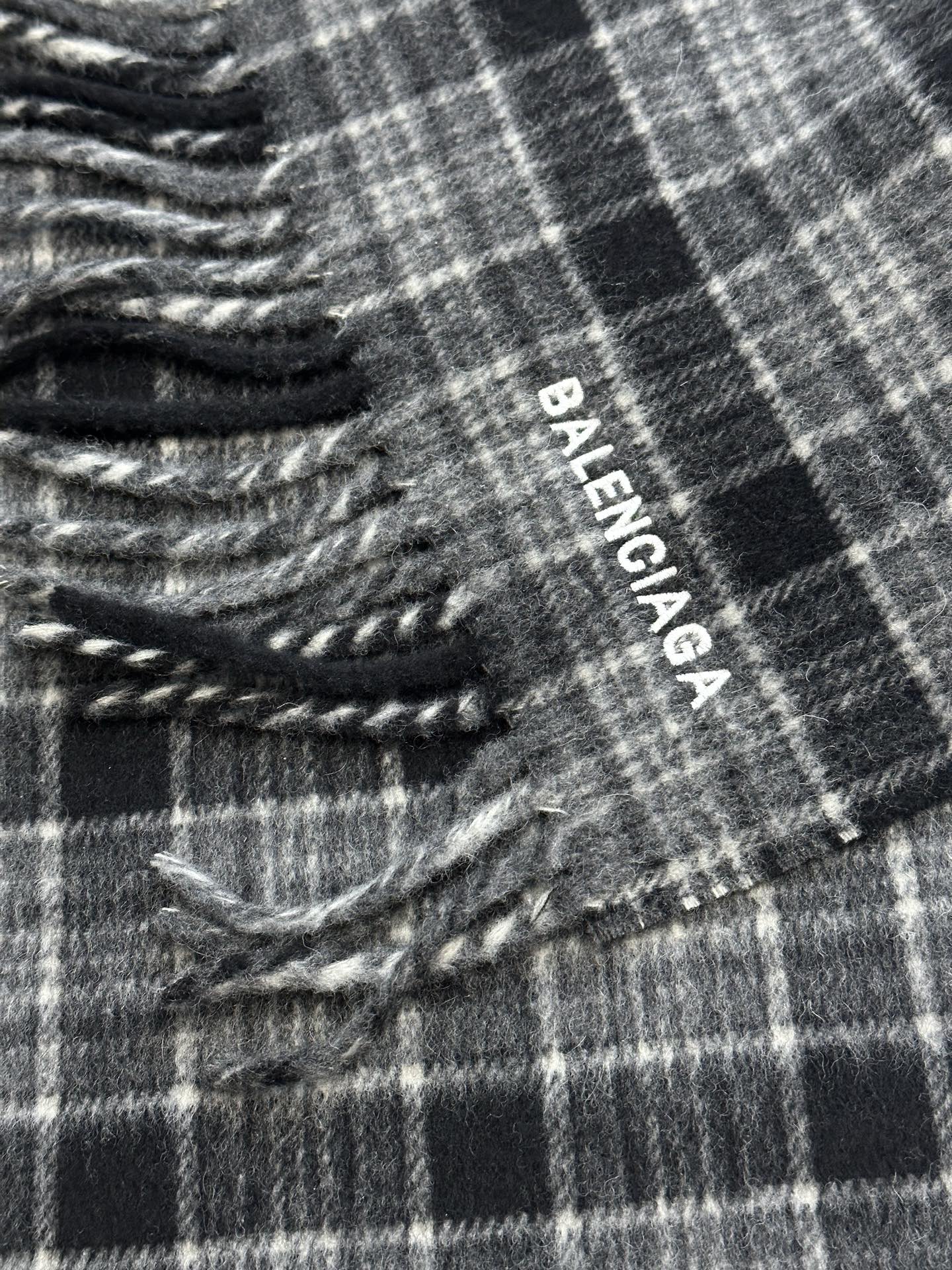 Balenciaga logo tag on plaid poncho with fringed edge