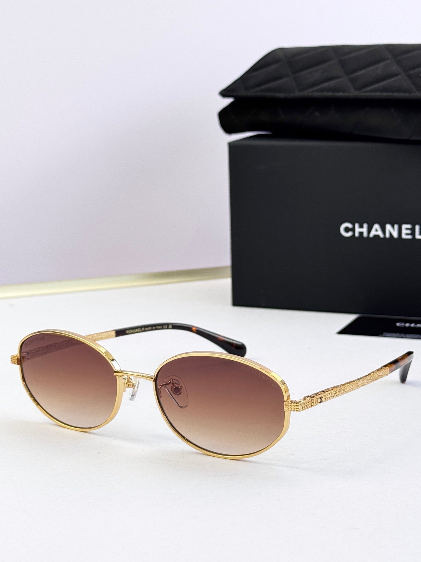Round sunglasses with gold frame and dark brown tinted lenses