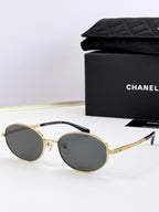 Round sunglasses with gold frame and dark gray tinted lenses