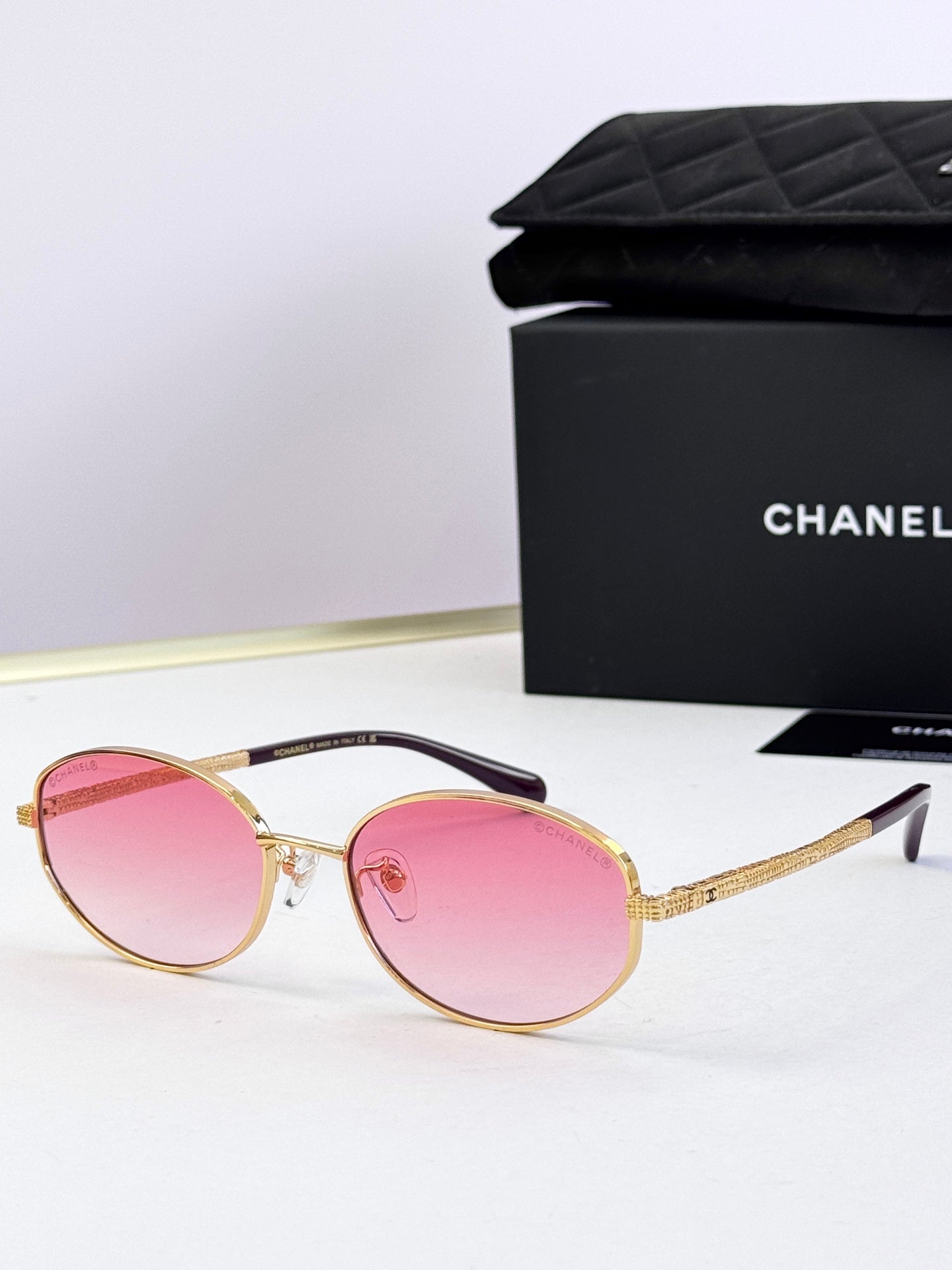Round sunglasses with gold frame and pink tinted lenses