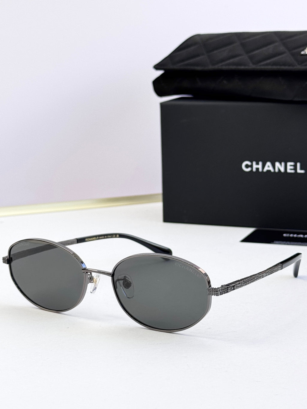 Round sunglasses with silver frame and dark gray tinted lenses