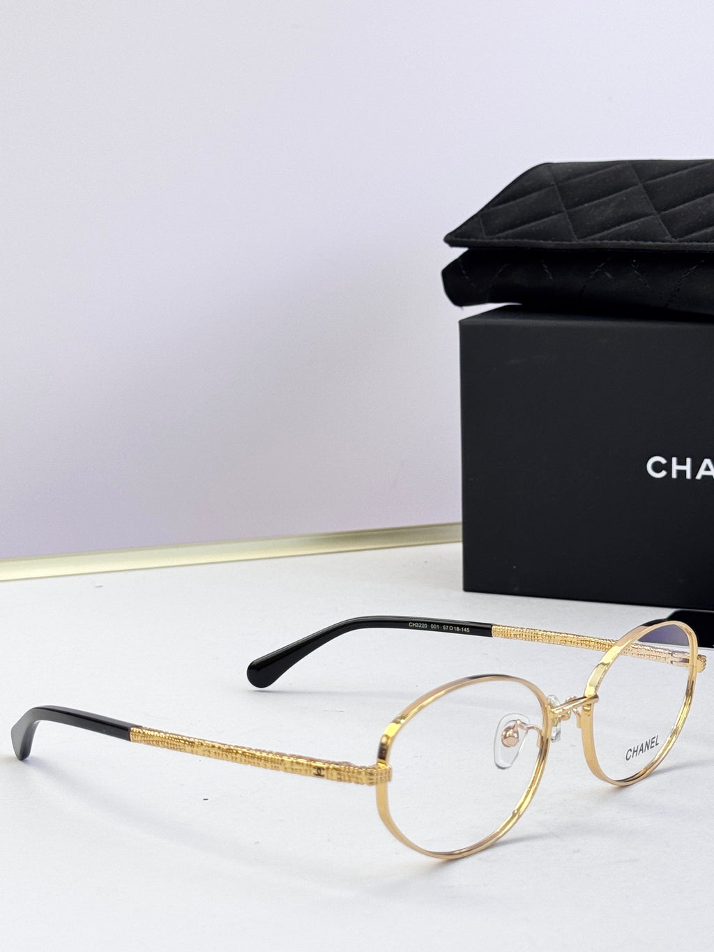 Chanel eyeglasses close-up with gold round frames and dark temples