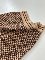 Knit polo shirt sleeve and hem edge with tan striped cuff and patterned knit