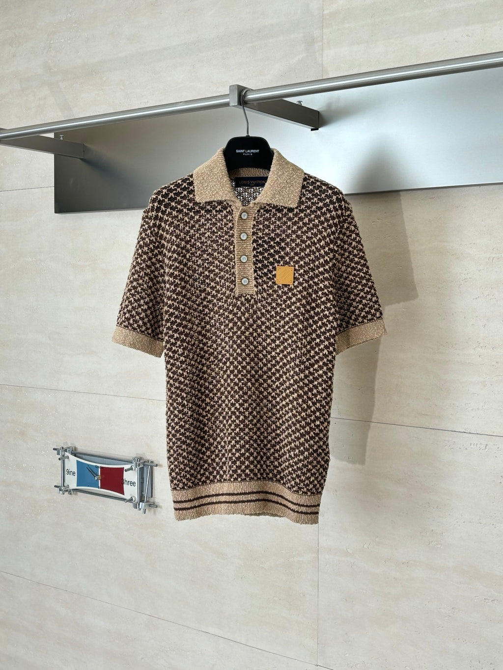 Knitted polo shirt with brown patterned knit, tan collar, button placket, logo patch
