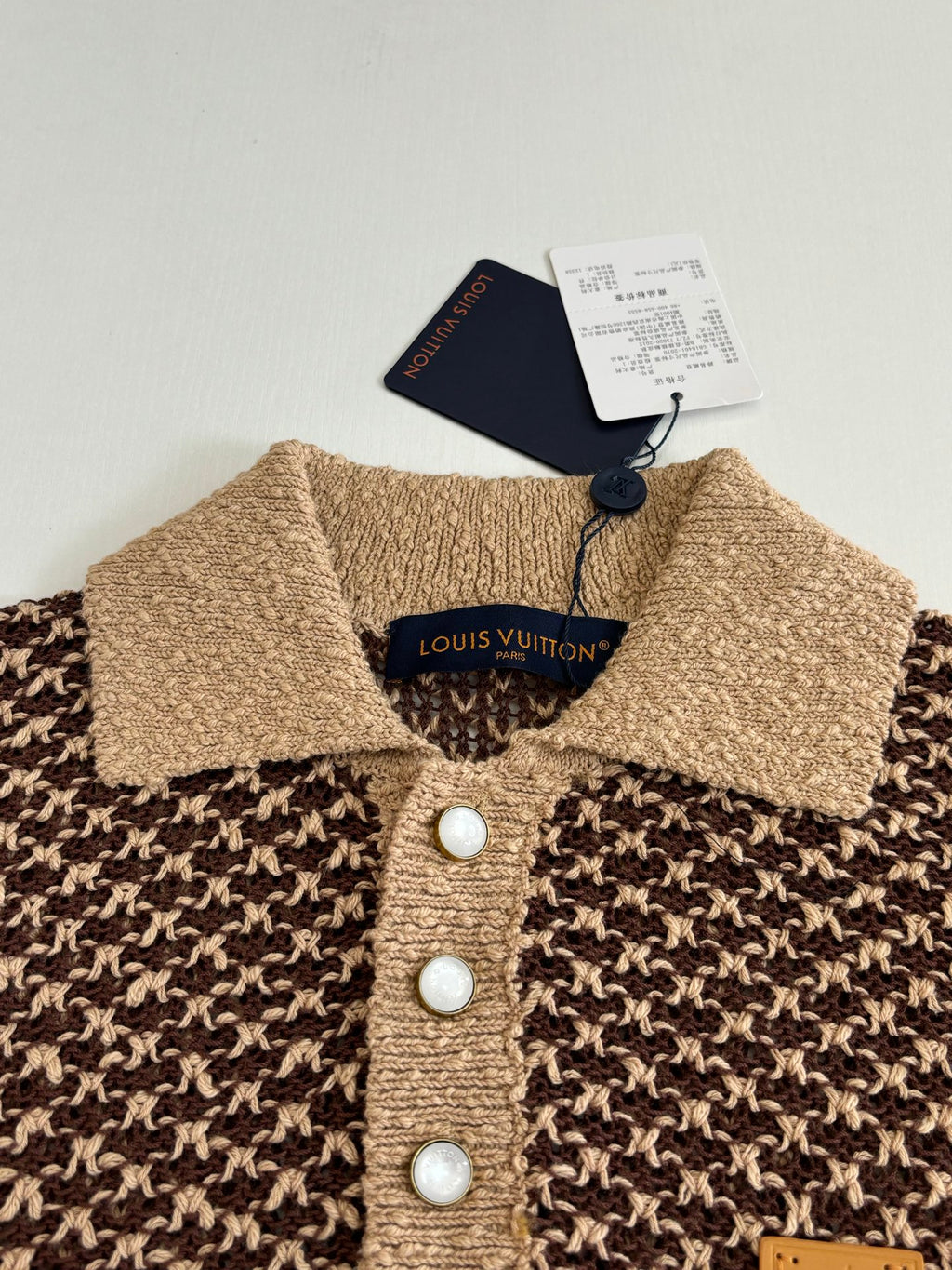 Knitted polo shirt collar and button placket with logo label, three white buttons