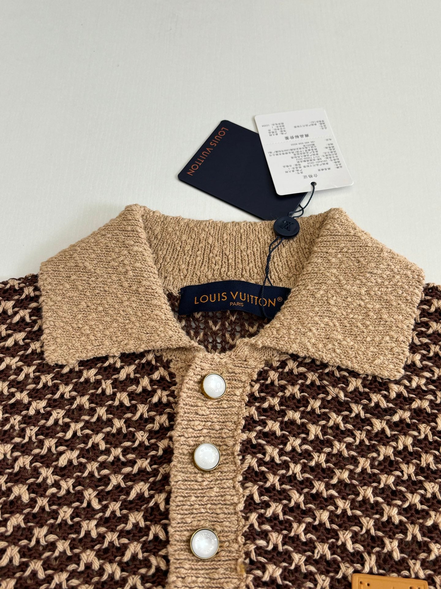 Knitted polo shirt collar and button placket with logo label, three white buttons