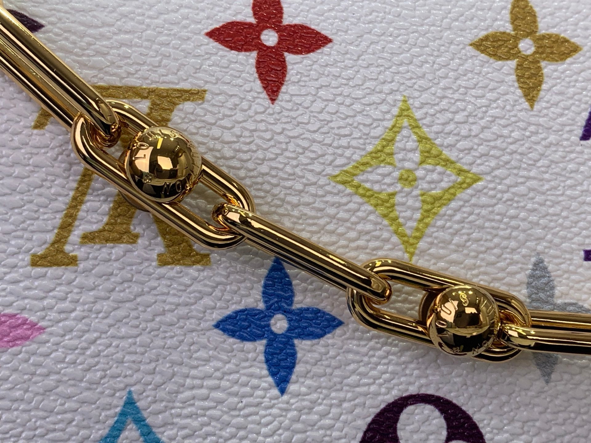 Gold-tone chain links over multicolor monogram canvas on a white Louis Vuitton bag