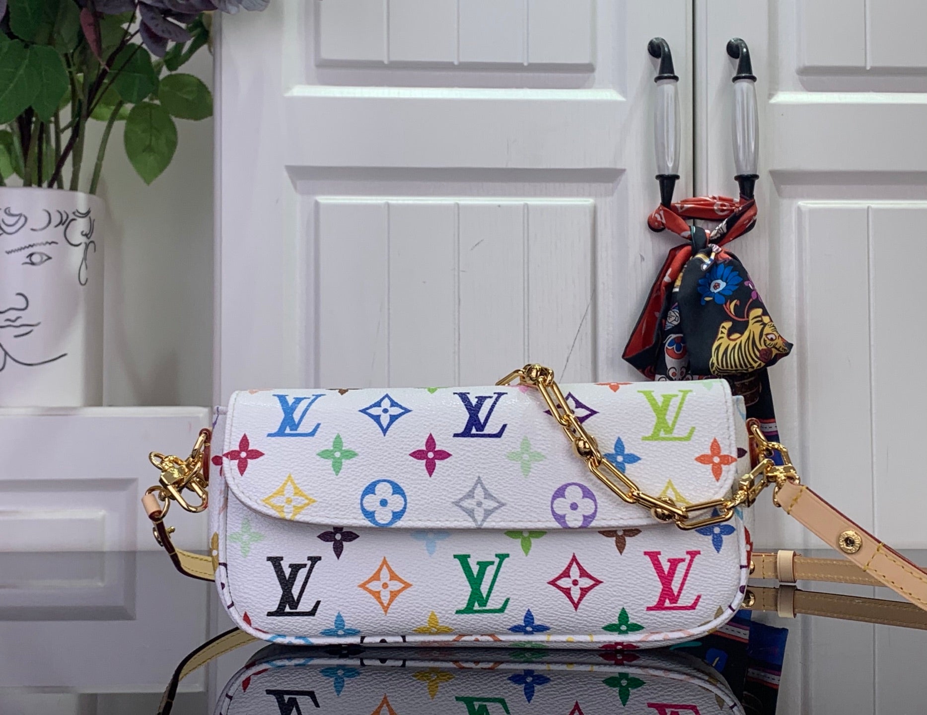White Louis Vuitton crossbody bag with multicolor monogram pattern and gold chain strap
